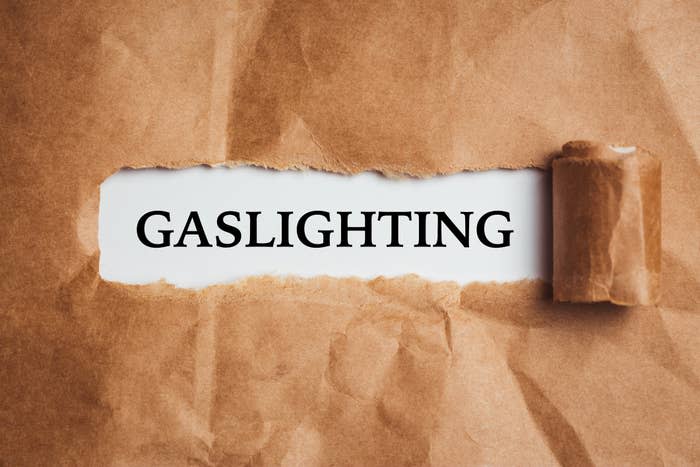 Torn brown paper revealing the word "GAS LIGHTING" under